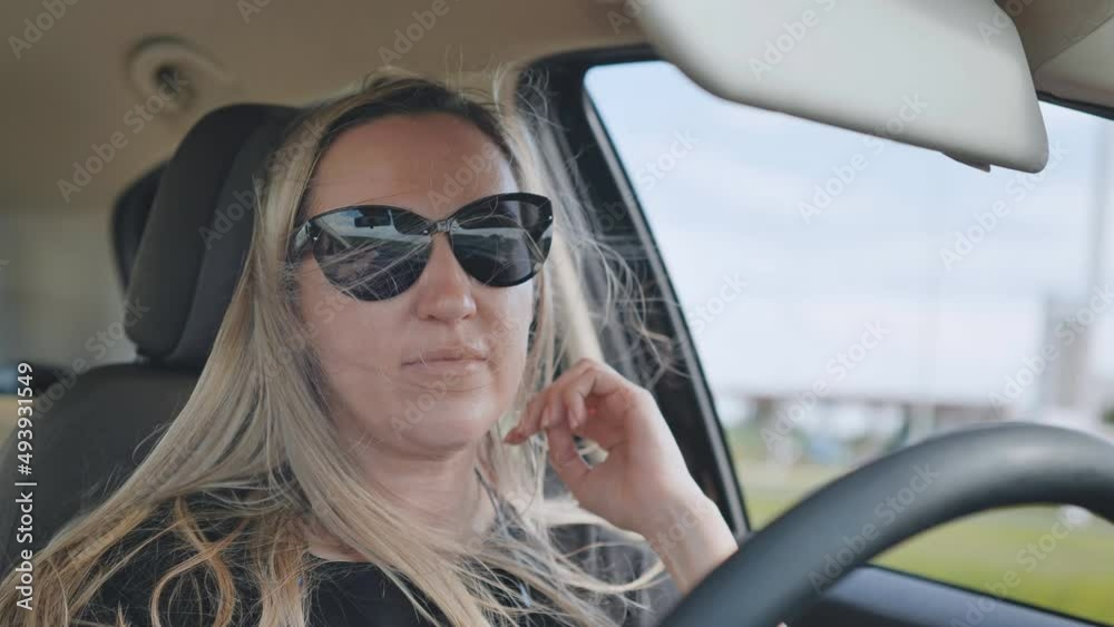 A young woman driving a car is driving on the highway. A young woman driving a car is driving on the highway.