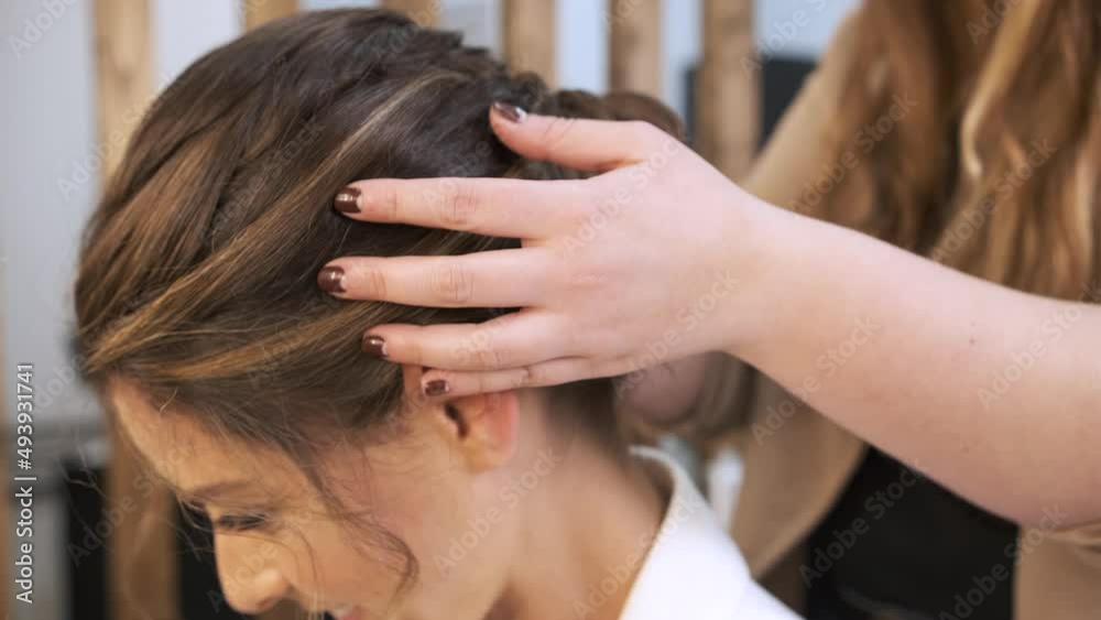 Professional stylist doing a wedding headdress to her female client at the beauty salon. Professional stylist doing a wedding headdress to her female client at the beauty salon.
