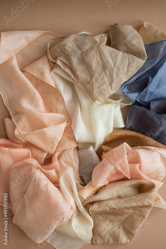 hand dyed clothes in warm natural tones on a bright background - text space -
slow fashion concept 
