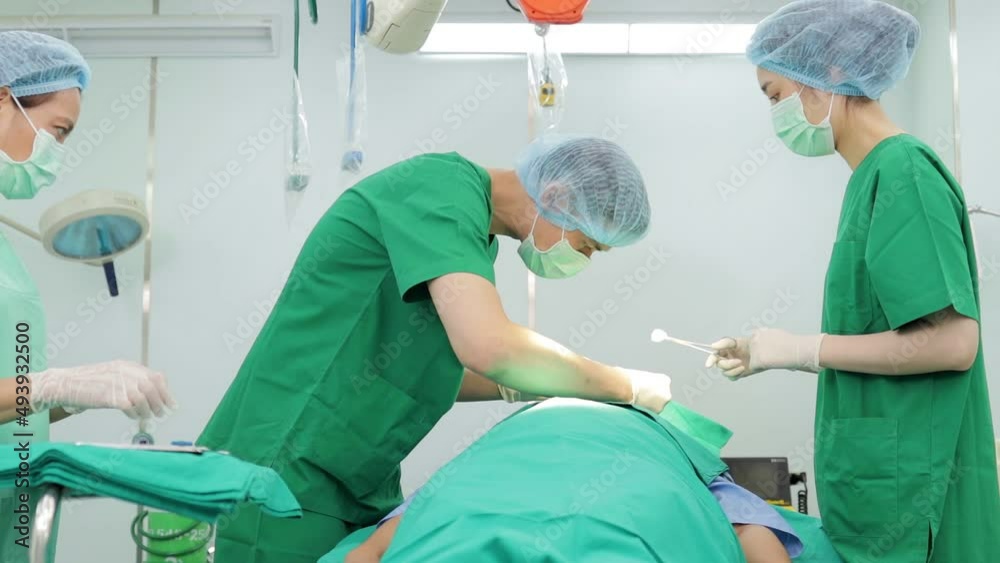 Professional team of Asian surgeons Perform surgery on a patient lying on a bed in a hospital operating room. medical concept Nose surgery. Cosmetic surgery. Professional team of Asian surgeons Perform surgery on a patient lying on a bed in a hospital operating room. medical concept Nose surgery. Cosmetic surgery.