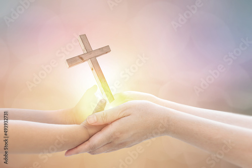 Baby Hand and Mom hand Holding Light-emitting cross asking for blessings from God