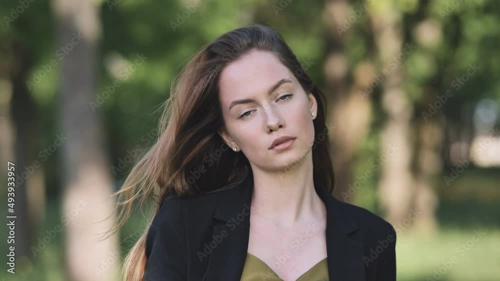 Portrait of a young business girl in a jacket in the park. Portrait of a young business girl in a jacket in the park.