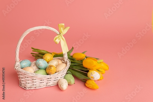 Easter eggs in baasket and yellow tulips bouquet. View with copy space. Easter postcard