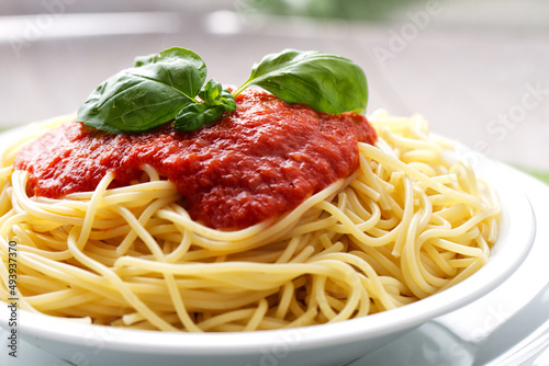 Spaghetti with tomato sauce and basil on a plate