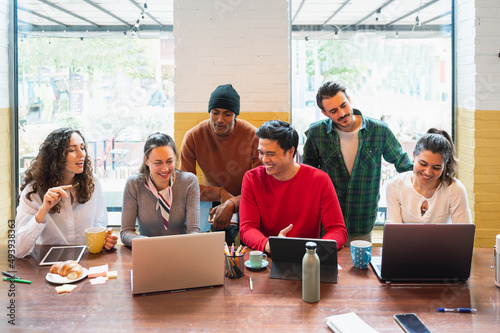 Front view group on young multiracial people with happy smiling faces working in a teamwork sitting at table.