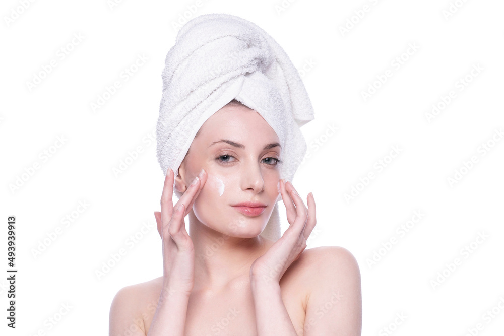 Beautiful woman with clean fresh skin applying cream on her face. Care treatment. Natural healthy cosmetic portrait manicure hand. Cosmetology, beauty and spa looking at camera Beautiful woman with clean fresh skin applying cream on her face. Care treatment. Natural healthy cosmetic portrait manicure hand. Cosmetology, beauty and spa looking at camera