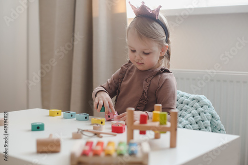  child playing and building with colorful wooden toys. Early learning and development