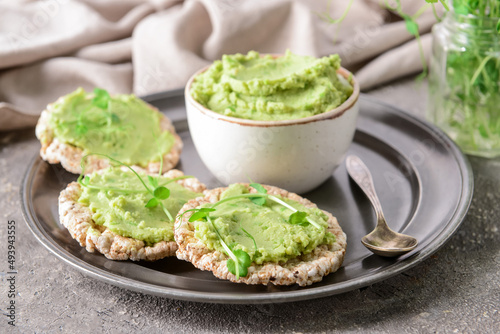 Tray with crispbreads and tasty pea hummus on grunge background
