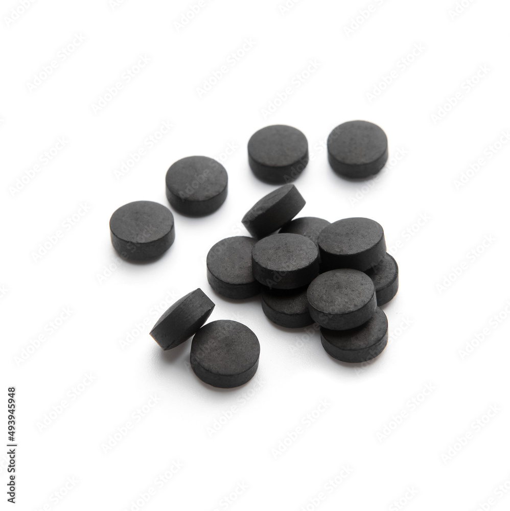 Heap of activated carbon pills isolated on white background Heap of activated carbon pills isolated on white background
