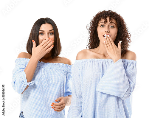 Surprised sisters on white ...