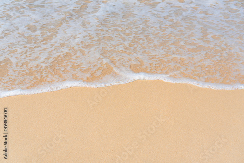 Top view of soft wave on sandy beach. Copy space