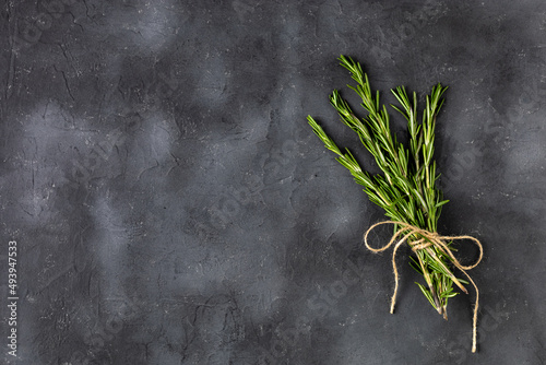 Bunch of green fresh rosemary on the dark black background. Herbs and spices for recipes.