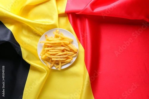 Plate with tasty french fries on Belgian flag, top view photo
