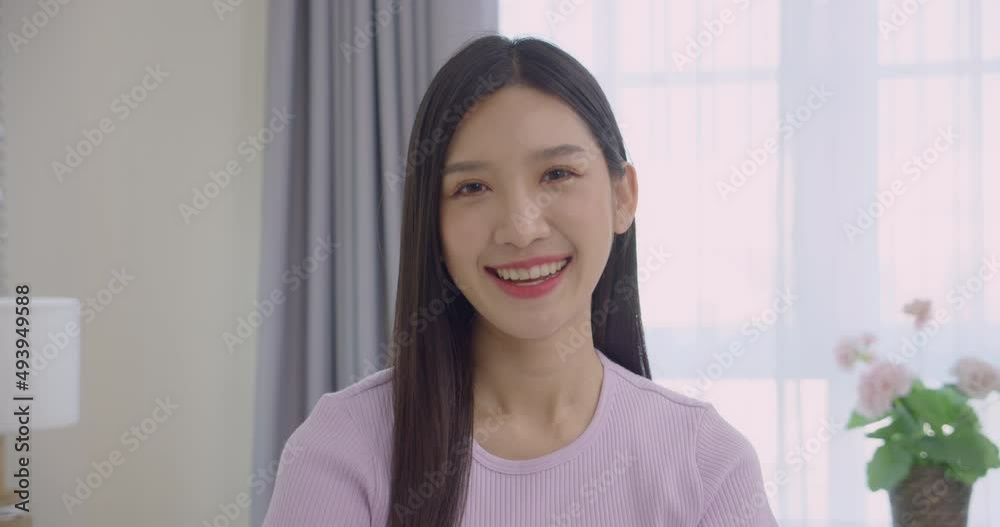 Slow motion close up portrait of beautiful asian young woman smiling happily in the room.Look at the camera and smiling confidently. Slow motion close up portrait of beautiful asian young woman smiling happily in the room.Look at the camera and smiling confidently.