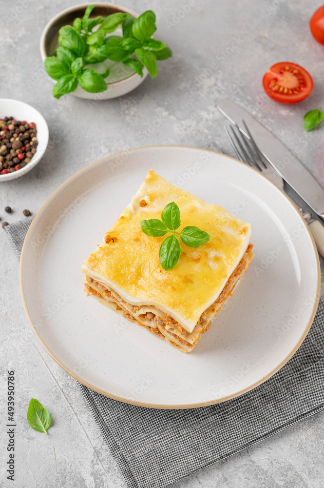 Slice of Lasagna bolognese with meat sauce and bechamel with melted cheese on top and fresh basil. Italian cusine. Copy space. Slice of Lasagna bolognese with meat sauce and bechamel with melted cheese on top and fresh basil. Italian cusine. Copy space.