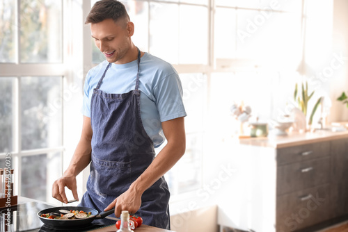 Handsome young man frying t...