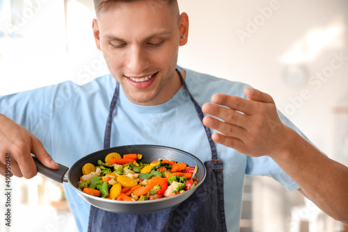 Young man holding frying pa...