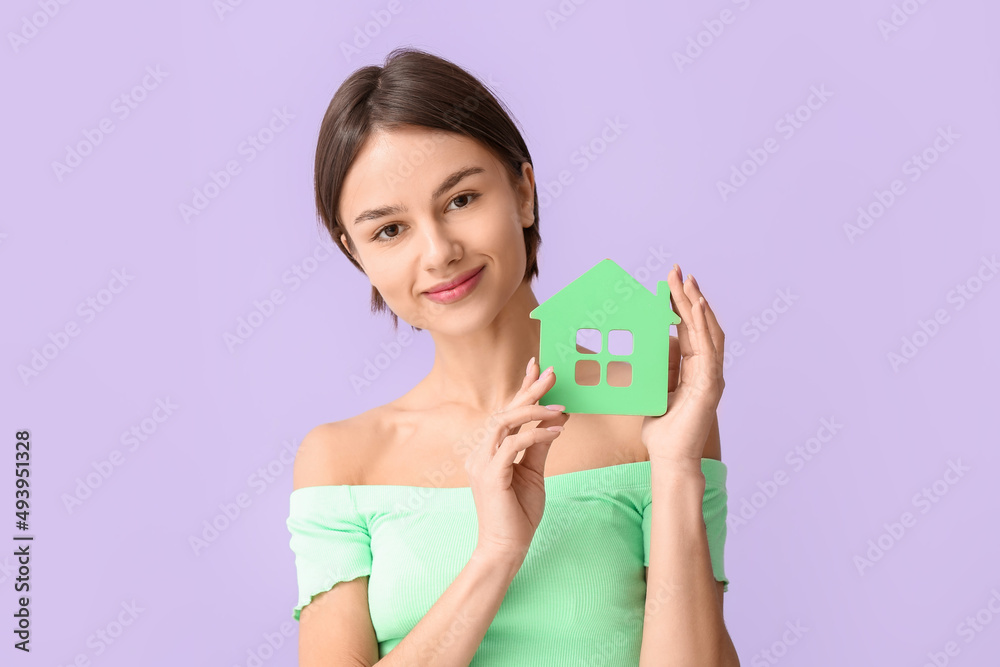 Beautiful young woman with figure of house on color background Beautiful young woman with figure of house on color background