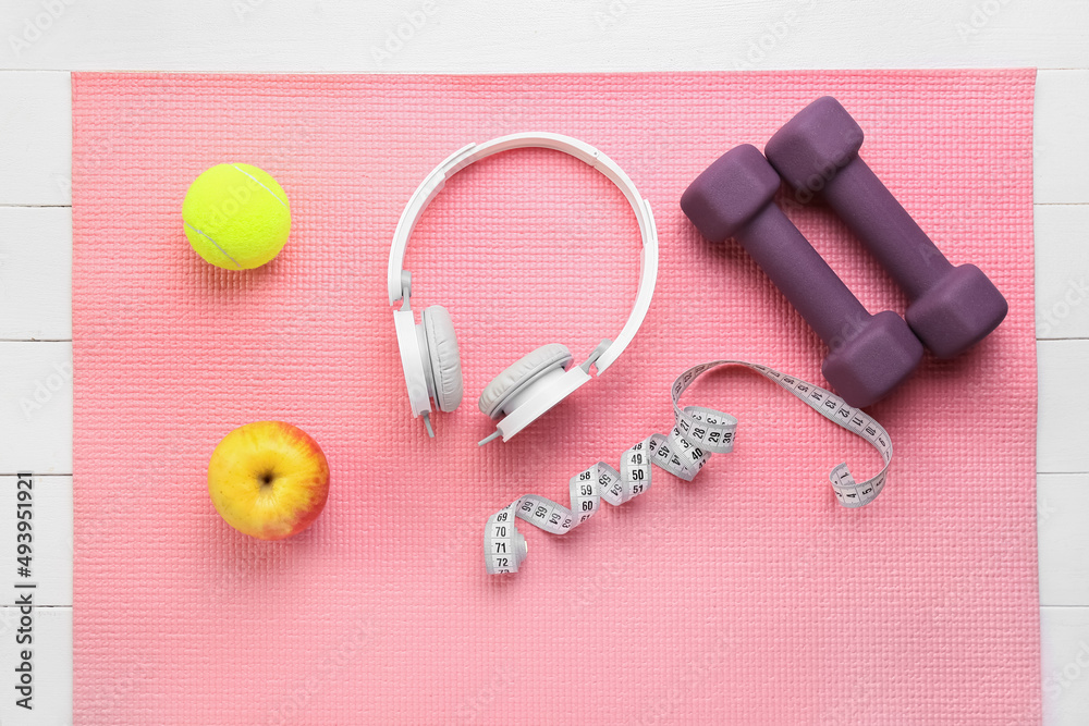 Stylish sport equipment and headphones on fitness mat Stylish sport equipment and headphones on fitness mat