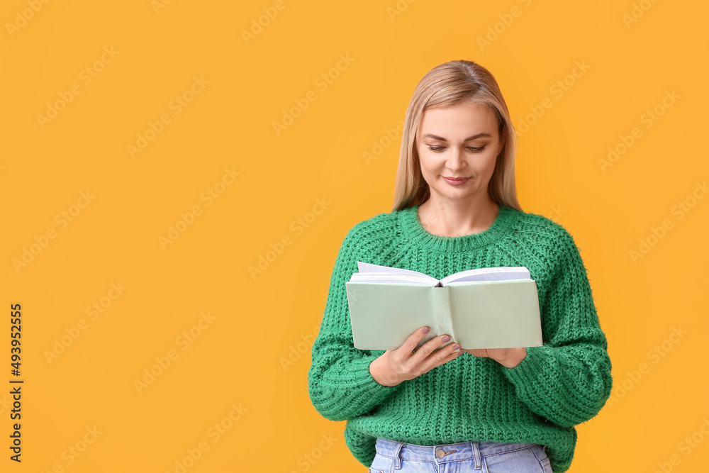 Beautiful woman reading book on yellow background Beautiful woman reading book on yellow background