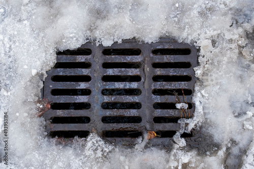 sewer grate covered with melting snow. Selective Focus