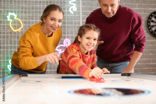 Family playing air hockey i...