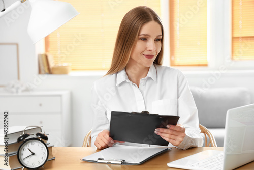 Beautiful businesswoman working with documents at table in office