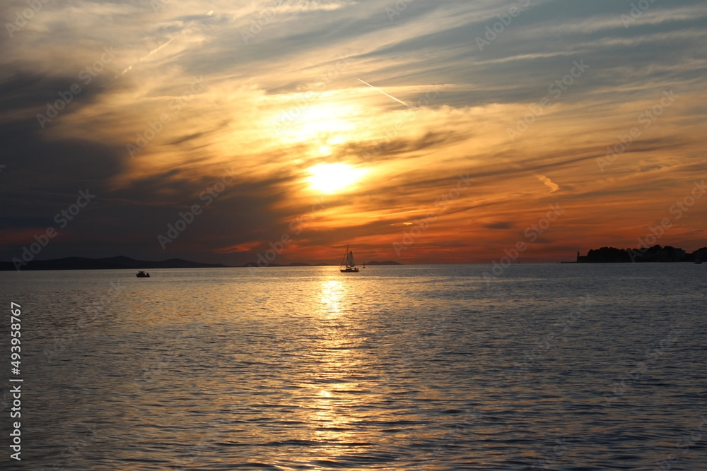 sunset at sea and boat. variety of colors and hues of the rising sun. Sea landscape.