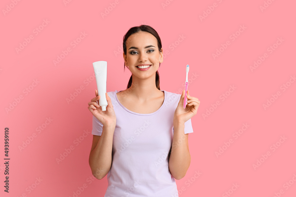 Smiling young woman with tooth paste and brush on pink background Smiling young woman with tooth paste and brush on pink background