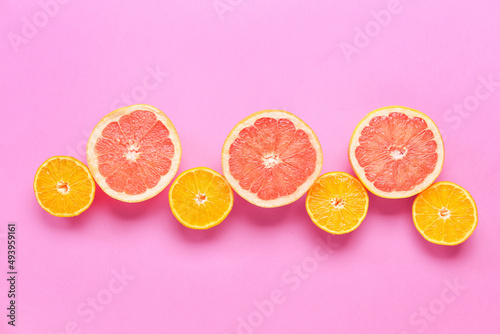 Fresh orange and grapefruit slices on pink background