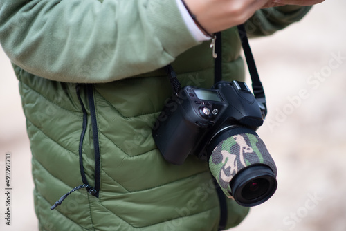 Close-up of modern photo camera. Person in coat with digital camera with big lens. Technology, hobby concept
