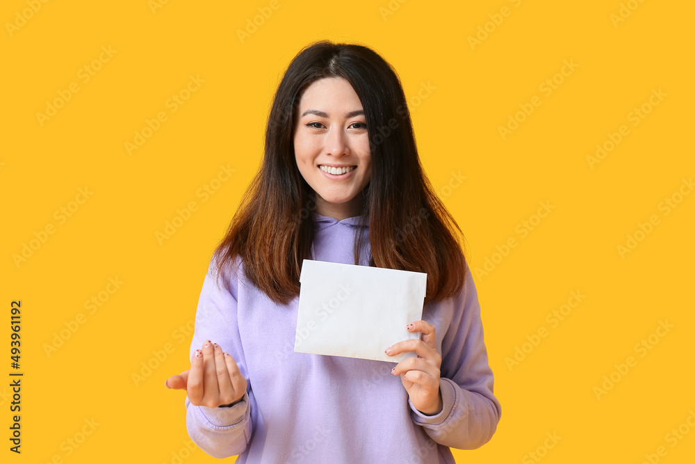 Young Asian woman with invitation showing Young Asian woman with invitation showing