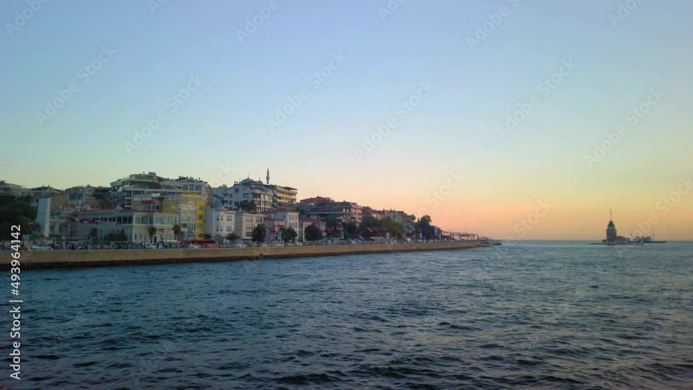 Istanbul, Turkey - ; Panning shot view of city during sunset time with sea waves .View of Istanbul city from the back of a ferryboat sailing on Bosphorus river. Istanbul, Turkey - ; Panning shot view of city during sunset time with sea waves .View of Istanbul city from the back of a ferryboat sailing on Bosphorus river.