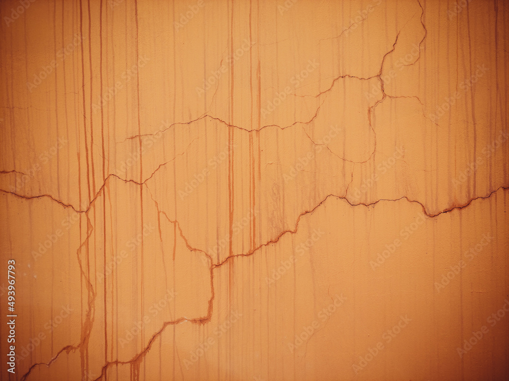 Orange cracked wall. Old blurred paint on a concrete wall. Orange cracked wall. Old blurred paint on a concrete wall.