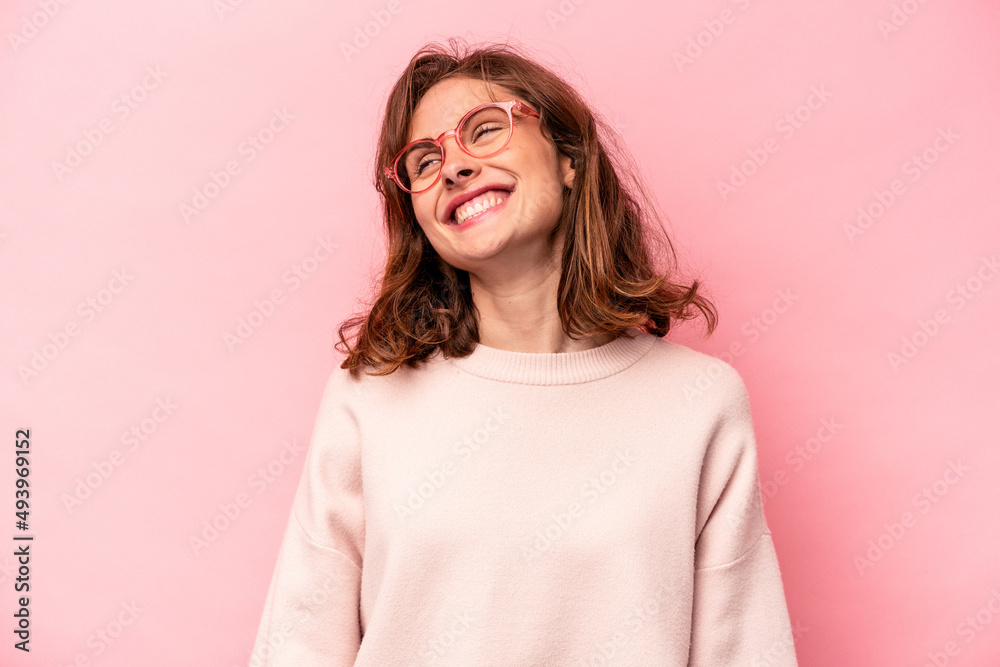 Young caucasian woman isolated on pink background relaxed and happy laughing, neck stretched showing teeth. Young caucasian woman isolated on pink background relaxed and happy laughing, neck stretched showing teeth.