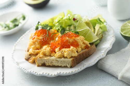 Scrambled eggs with red caviar on toast