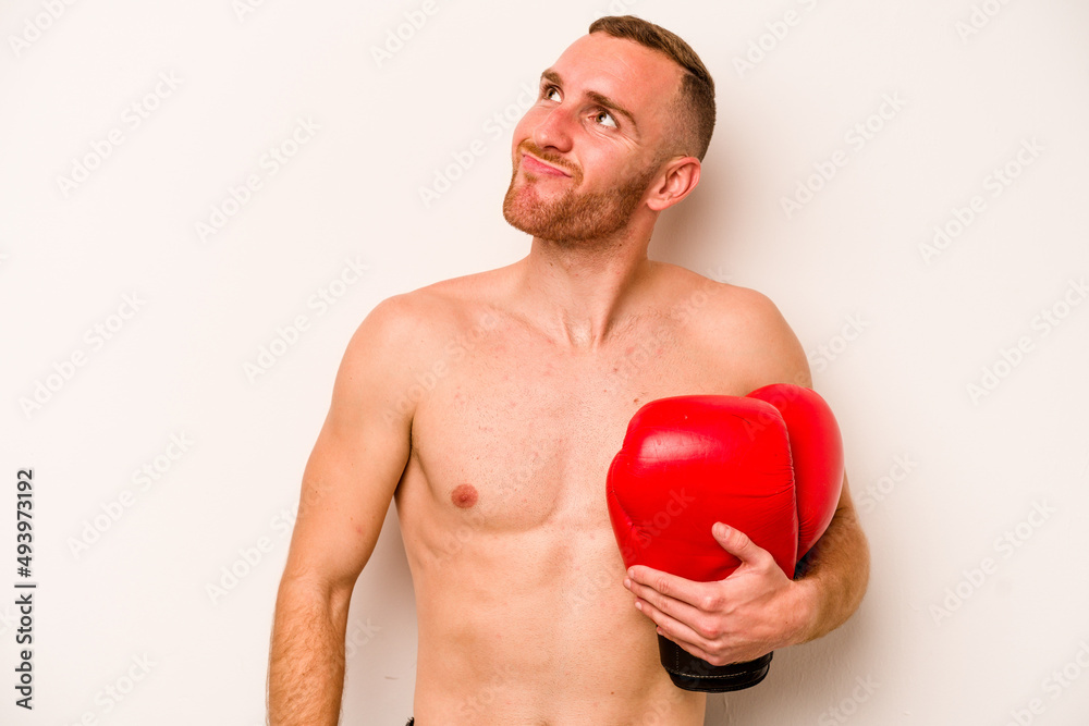 Young caucasian man doing boxing isolated on white background dreaming of achieving goals and purposes