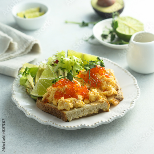 Scrambled eggs with red caviar on toast