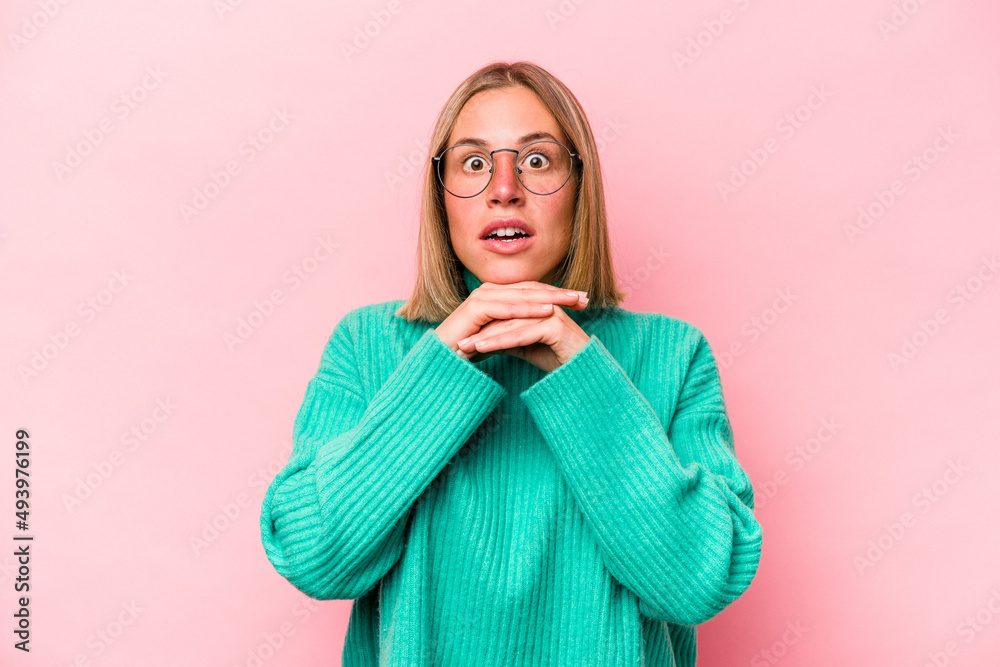 Young caucasian woman isolated on pink background praying for luck, amazed and opening mouth looking to front. Young caucasian woman isolated on pink background praying for luck, amazed and opening mouth looking to front.