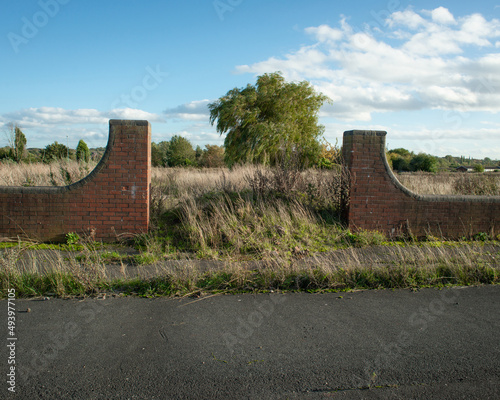 Slika na platnu Abandoned road and brick structure on brownfield site