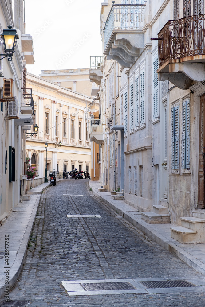 Neoclassical building and empty paved street at Syros island, Hermoupolis town, Cyclades, Greece