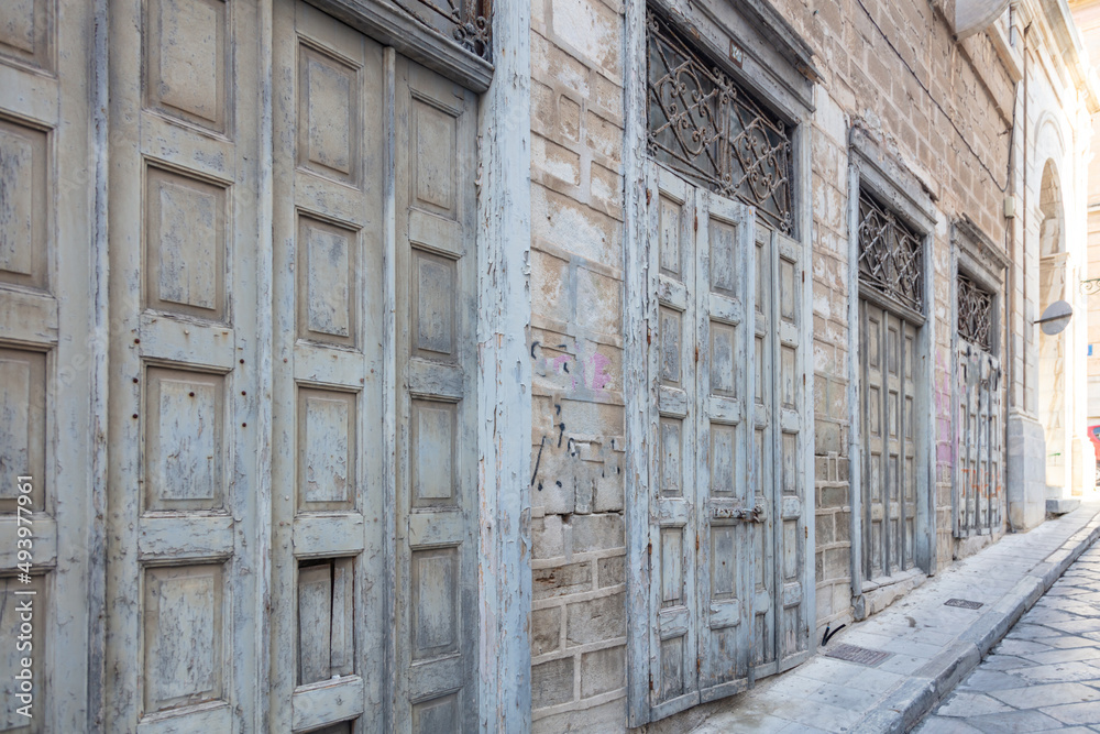 Ruined facade and doors, abandoned damaged building at Ermoupolis, Syros island Greece.