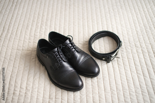 Black men's shoes with laces and a black belt
