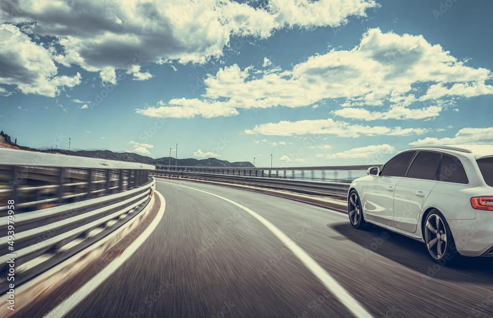 White car on a scenic road. Car on the road surrounded by a magnificent natural landscape. White car on a scenic road. Car on the road surrounded by a magnificent natural landscape.