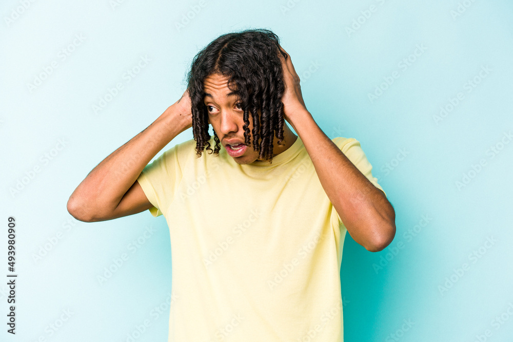 Young African American man isolated on blue background screaming, very excited, passionate, satisfied with something. Young African American man isolated on blue background screaming, very excited, passionate, satisfied with something.