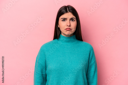Young caucasian woman isolated on pink background sad, serious face, feeling miserable and displeased. © Asier