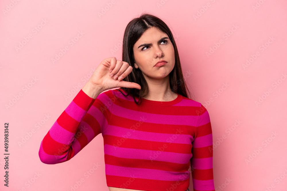 Young caucasian woman isolated on pink background showing a dislike gesture, thumbs down. Disagreement concept.