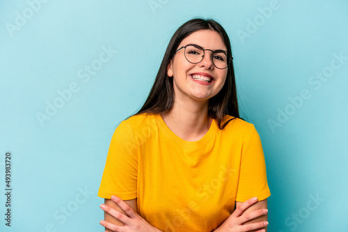 Young caucasian woman isolated on blue background laughing and having fun.