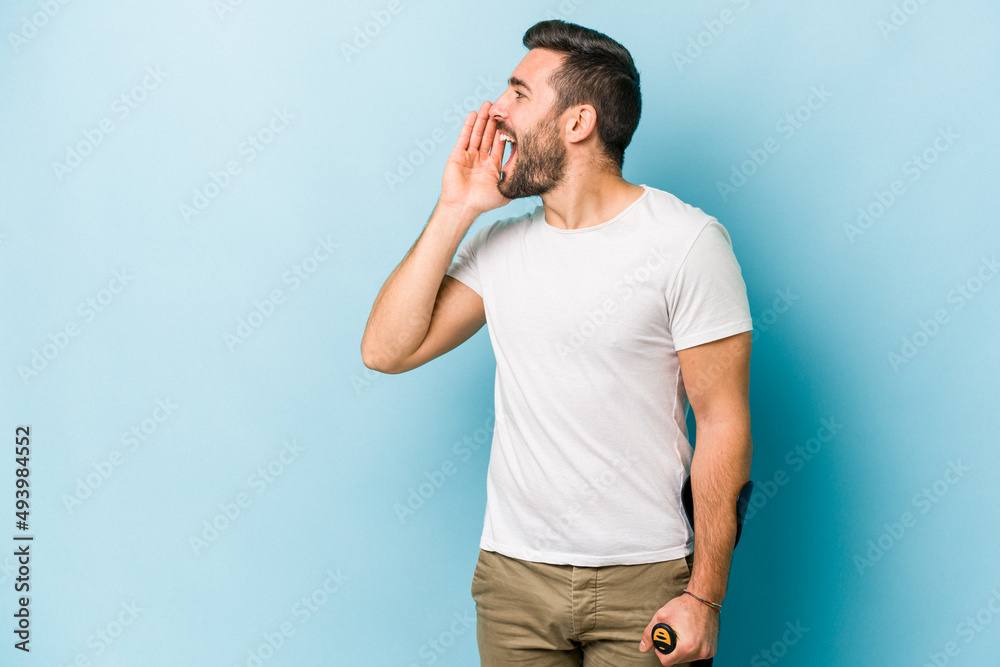 Young man with crutches isolated on blue background shouting and holding palm near opened mouth. Young man with crutches isolated on blue background shouting and holding palm near opened mouth.