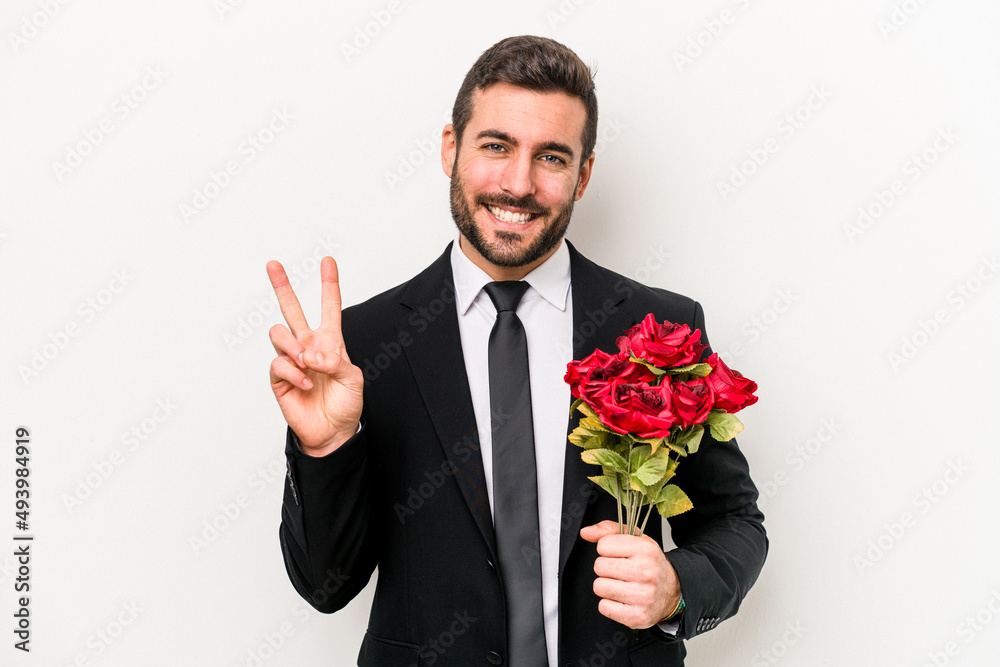 Young caucasian man holding a bouquet of flowers isolated on white background showing number two with fingers. Young caucasian man holding a bouquet of flowers isolated on white background showing number two with fingers.